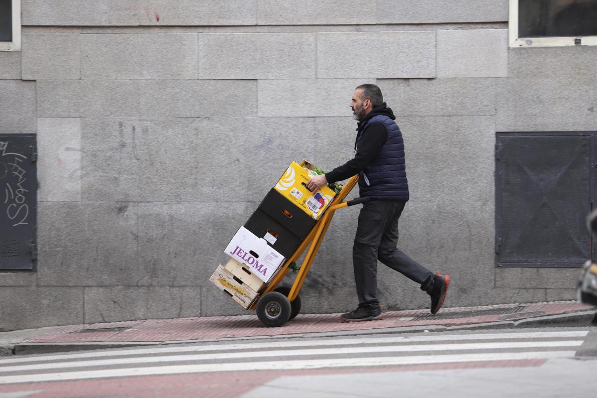 Una persona lleva unos paquetes en una calle de Madrid