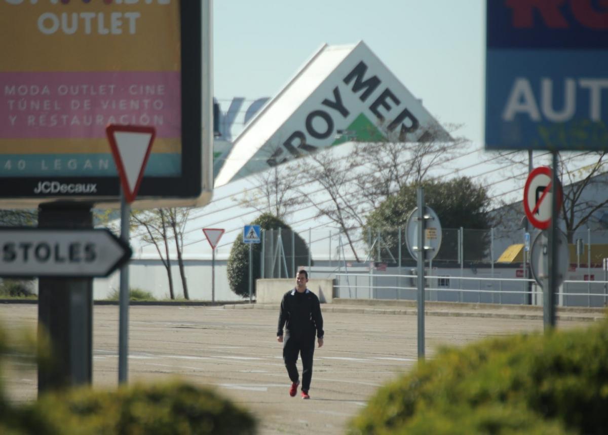 Un hombre camina solitario por la zona comercial Parque Oeste en Mstoles durante la crisis del coronavirus