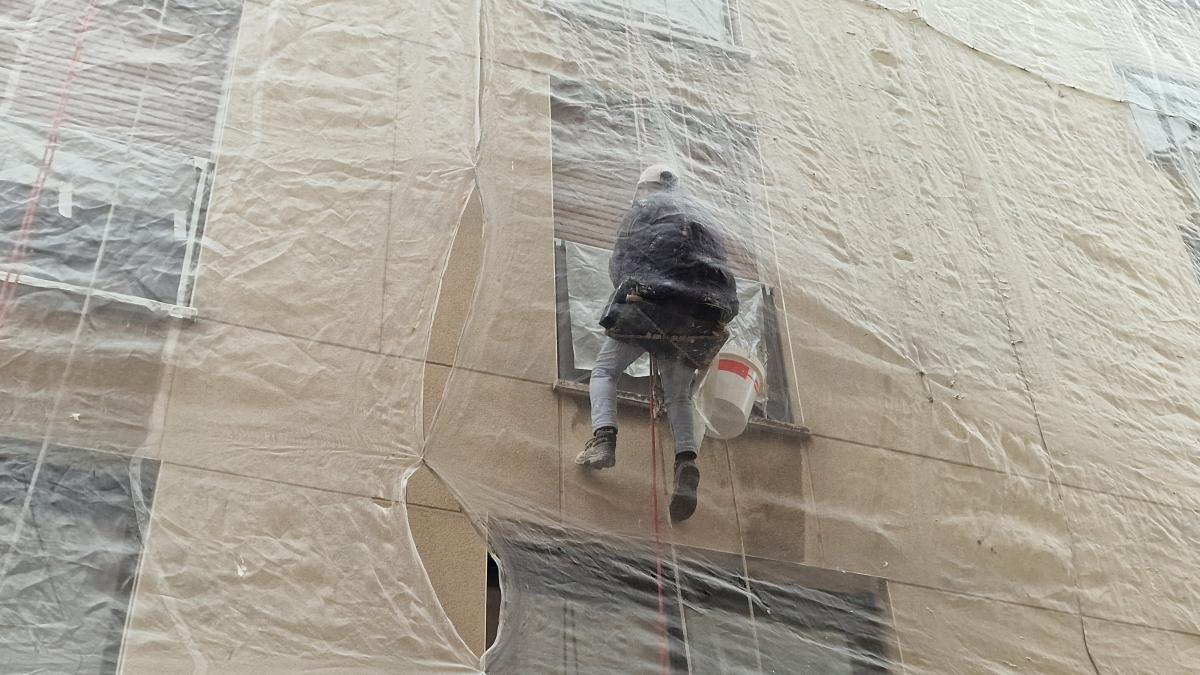 Un trabajador en una fachada de una calle céntrica de Madrid